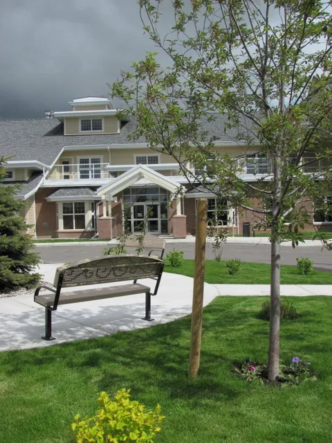 Garden bench beside a path and lawn in front of the building