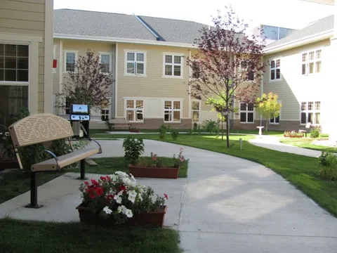 Courtyard path with a bench, flower planters and trees