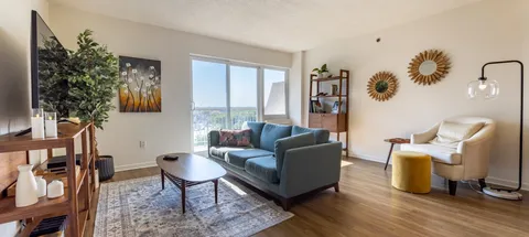 Sitting area with a teal sofa, an armchair and a coffee table