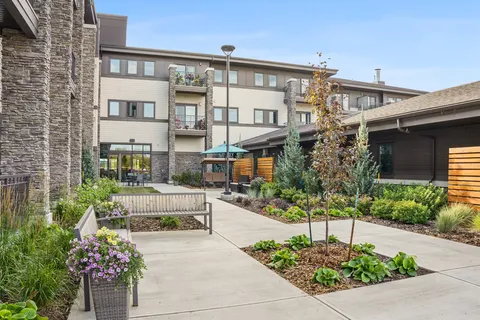 Residence buildings beside a courtyard with planted beds and benches