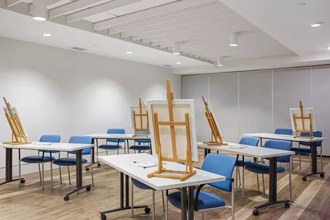 Room with easels, tables and blue chairs