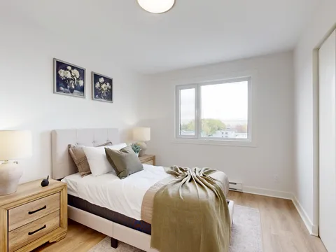 Bedroom with a bed, nightstand and window.