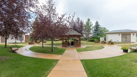 Garden paths, lawn, benches and a wooden gazebo.
