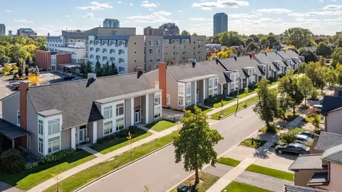 Row of homes with lawns beside a tree-lined street