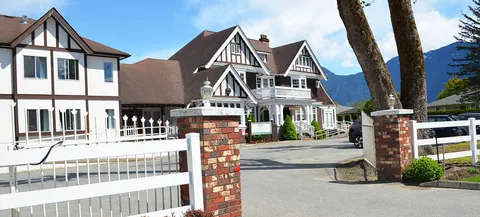 White building with peaked roofs, balconies and a covered entrance