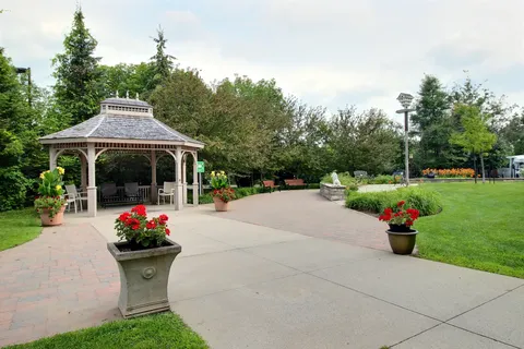 Garden patio with a gazebo, flower planters and a lawn