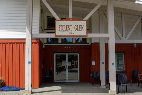 Covered main entrance with glass doors beneath the Forest Glen sign.