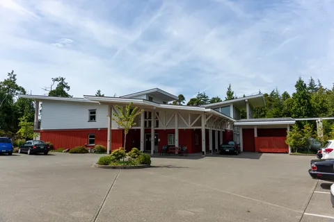 Residence exterior with a covered entrance and paved parking area.