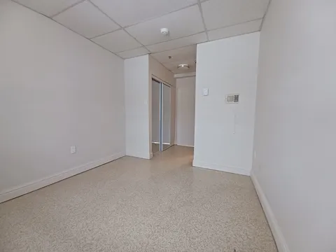 Empty room with white walls, a mirrored closet and a doorway