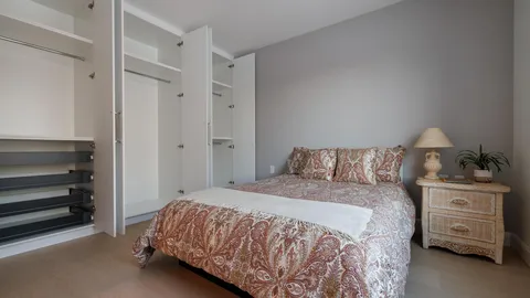Bedroom with a bed, wardrobe and wooden bedside table.