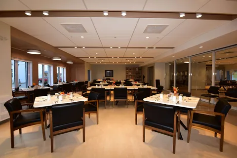 Dining room with tables, chairs and wide windows.