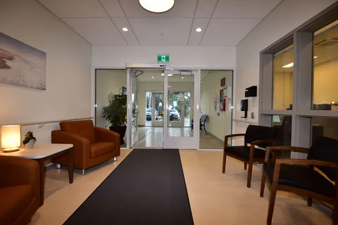 Entrance lounge with leather chairs beside glass doors.