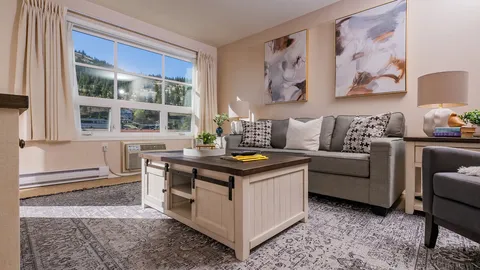 Suite living room with a sofa, coffee table and large window.