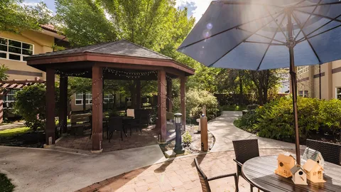 Courtyard gazebo and patio seating surrounded by greenery.