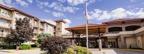 Residence exterior with covered entrance, balconies and landscaped beds.