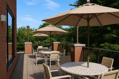 Terrace tables and chairs shaded by patio umbrellas.