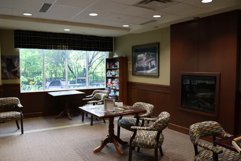 Games lounge with a fireplace, armchairs and puzzle tables.