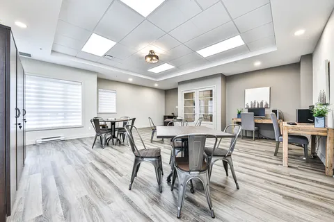 Activity room with tables, chairs and cabinets.