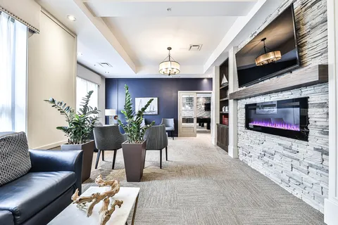 Lounge with sofas, windows and a stone fireplace wall.