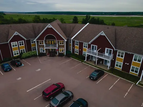 Aerial view of a red building with white balconies and a front car park