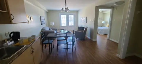 Open suite with kitchen counter, dining table and sitting area