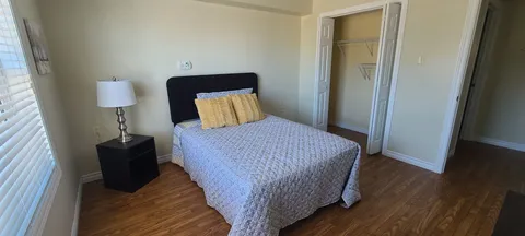 Bedroom with a bed, bedside lamp and open doorway