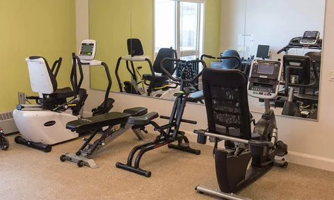 Exercise room with seated fitness machines and mirrored walls
