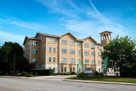 Four-storey brick residence with a tower, front lawn and driveway