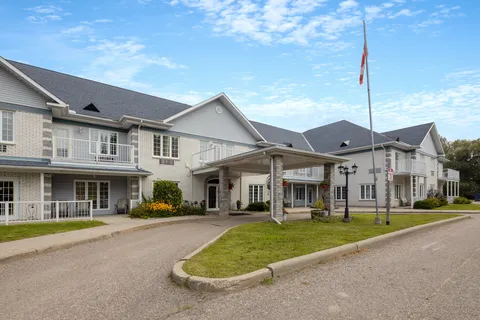 Residence facade with balconies, a covered driveway and flagpole.