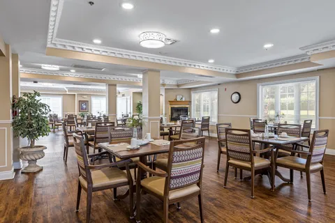 Dining room with set tables, wood chairs and large windows.