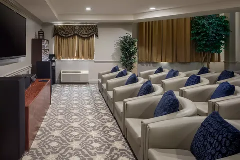 Rows of upholstered chairs facing a blank television screen