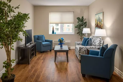 Sofa and blue armchairs around a coffee table beside large windows