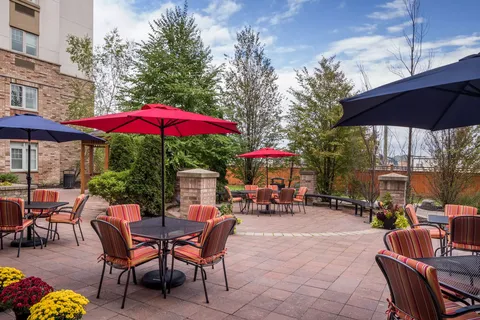 Patio seating beside trees, shrubs and flower beds