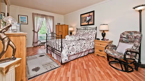 Bedroom with a metal bed frame and an armchair.