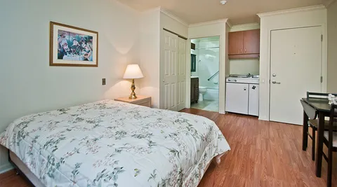 Studio bedroom with a kitchenette and table.