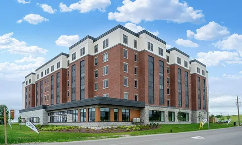 Multi-storey brick residence with a glass-fronted ground floor.