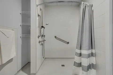 Accessible shower with a handheld showerhead and grab rails