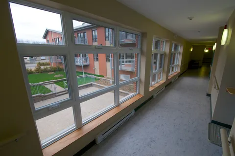 Windowed corridor overlooking the courtyard and residence balconies.