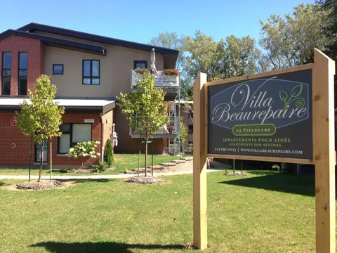 Residence sign beside the brick building and lawn.