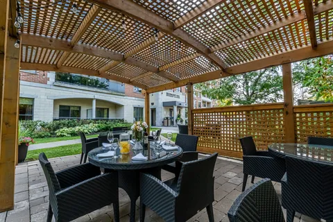 Patio dining tables and chairs under a wooden pergola