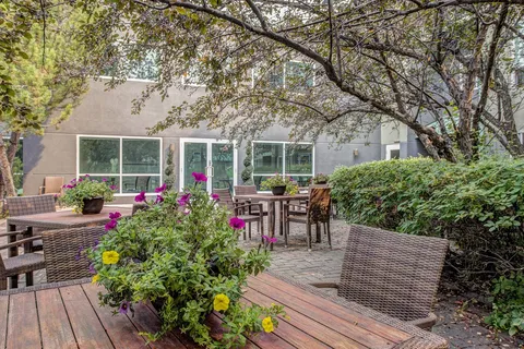 Courtyard patio with tables, chairs and flowering plants.