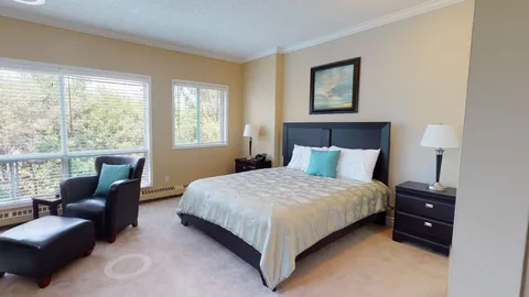 Studio suite with a bed and seating beside the window.