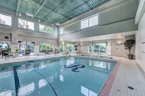 Indoor swimming pool beneath a glazed roof.
