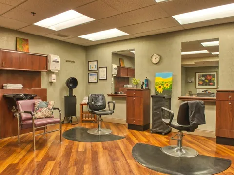 Hair salon with styling chairs, mirrors, cupboards and a hair dryer