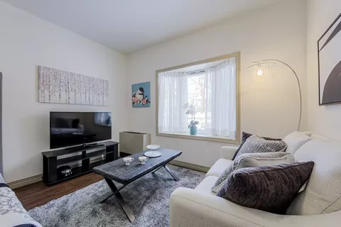 Sitting area with a sofa, television, coffee table and bird artwork