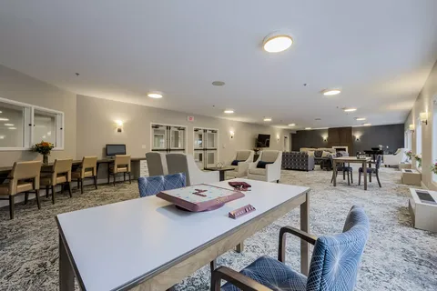 Games area with tables, blue chairs and seating in the background