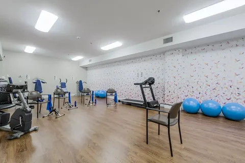 Fitness room with exercise machines, blue balls and chairs