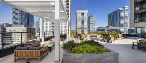 Rooftop terrace with planters, benches, tables and a pergola
