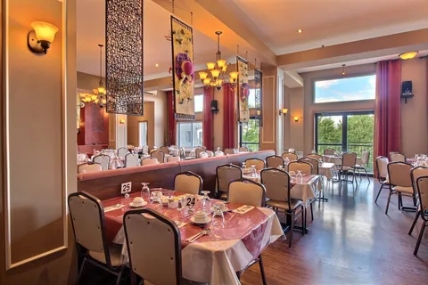 Dining room with set tables beside large windows.
