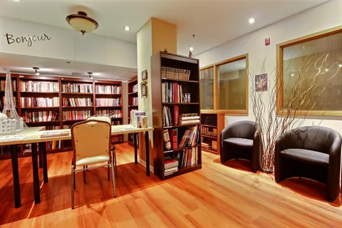 Library with bookshelves, tables and chairs.